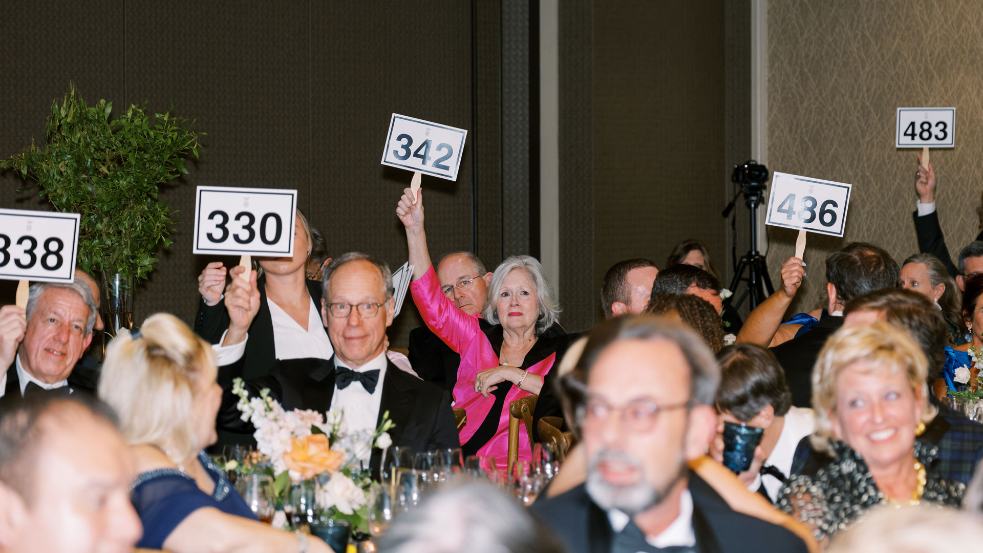 attendees holding auction signs